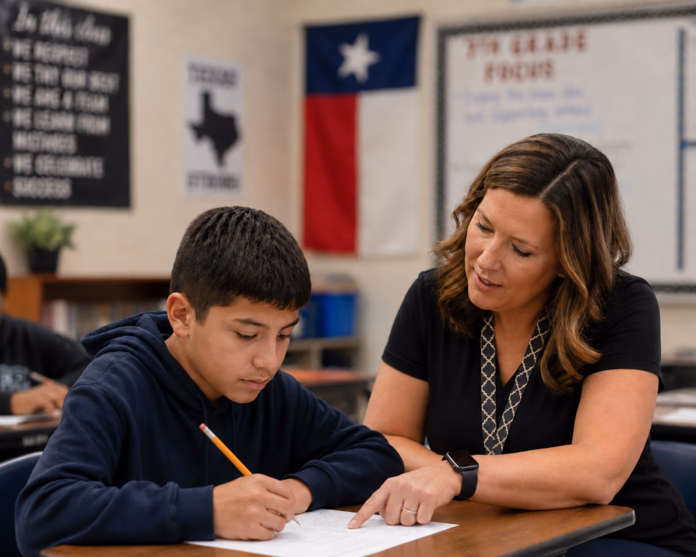Teacher and student working together at a classroom desk