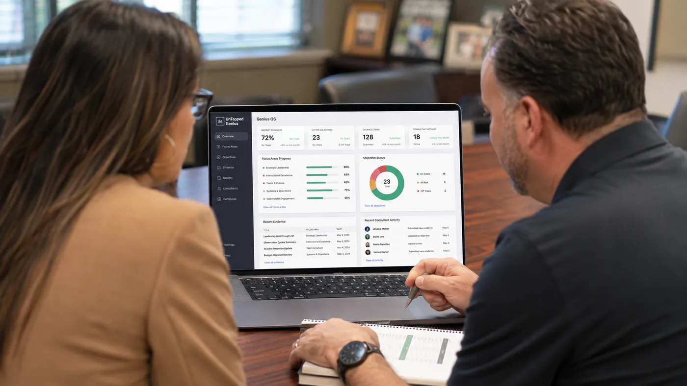 Two UnTapped Genius team members reviewing district progress and evidence inside Genius OS on a laptop